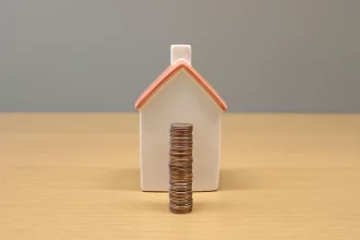 An image of a house and coins.