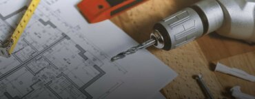 A picture of a drill and a metal tape measure.